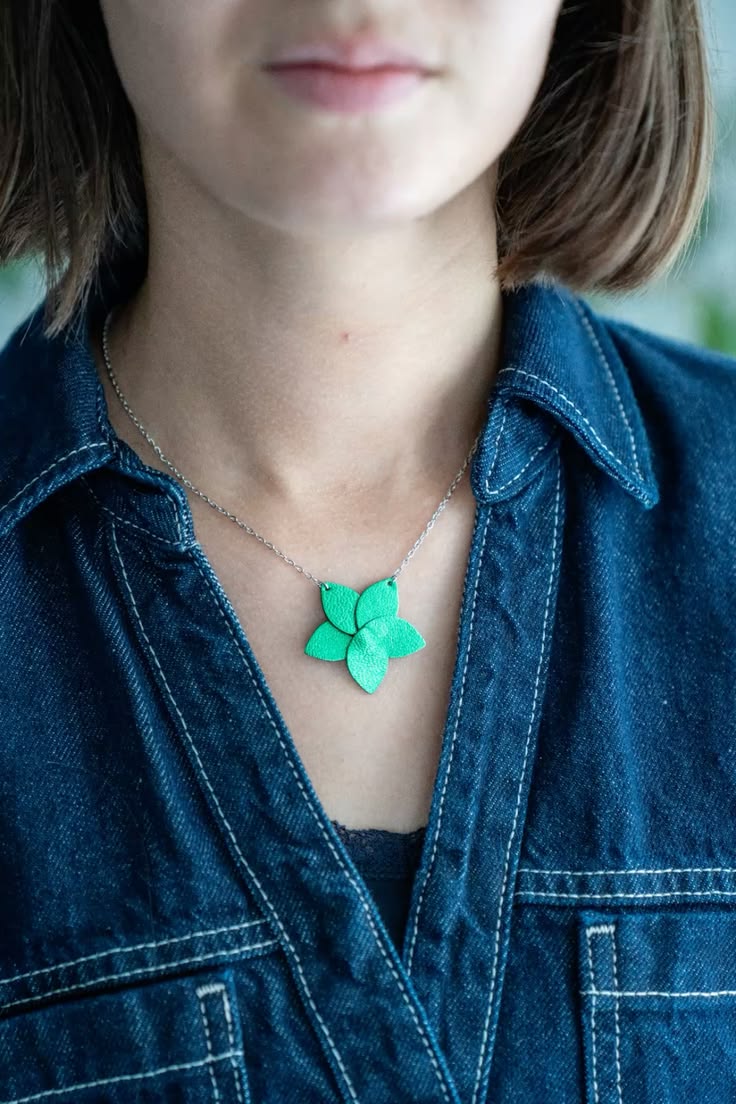 Ce collier court et léger, avec son pendentif en cuir vert m