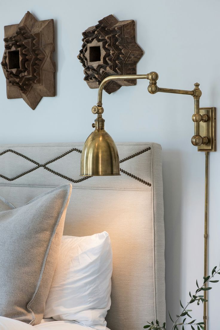 Bedroom reading nook with adjustable brass swing-arm wall sc