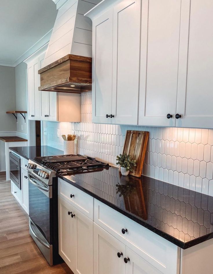 Farmhouse kitchen with black quartz countertops, white cabin