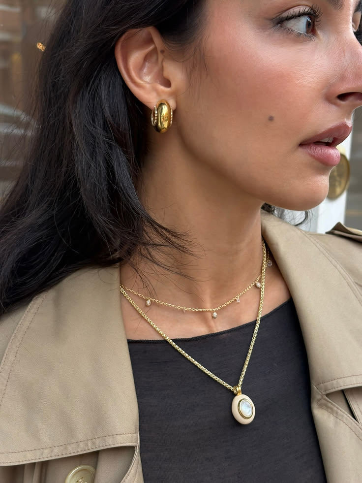 A close-up in cream and gold. The Core Pendant in cream resi