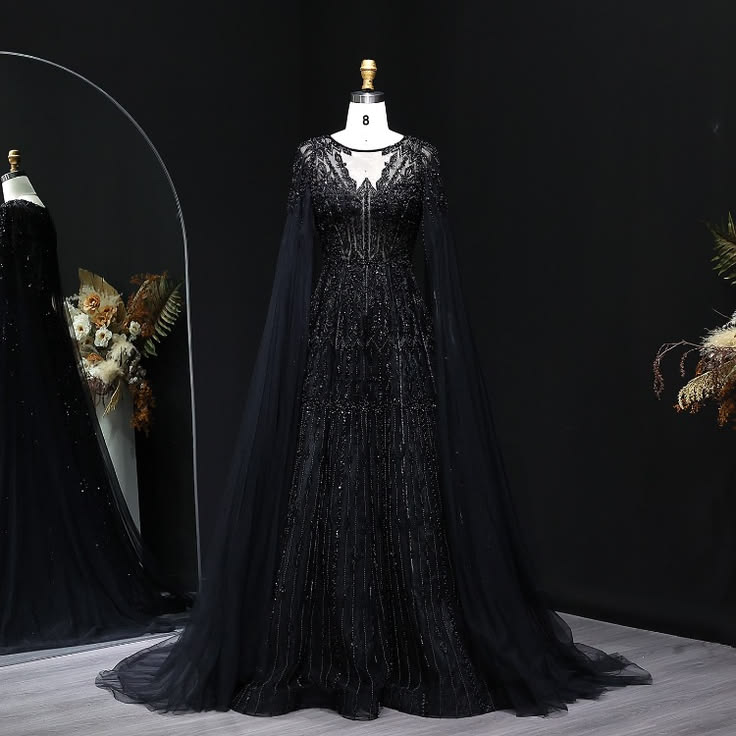 This beaded cape evening gown features a sheer neckline, int
