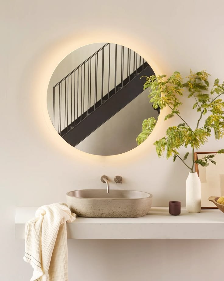 Elevate your space with a lit oval mirror, plant accents, an