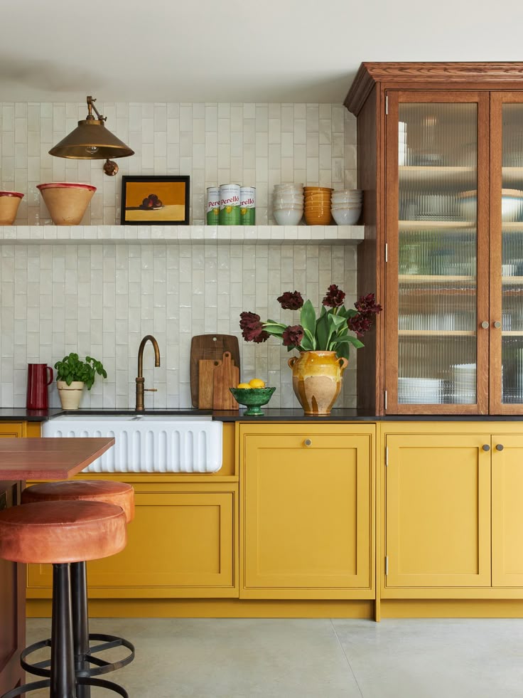 Yellow Cabinets with Black Countertops and Vertical Subway T