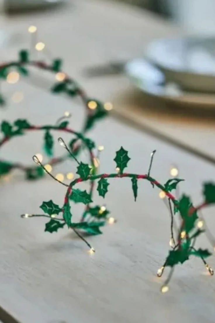 Fabric holly leaves entwined with red cord and green wire ba