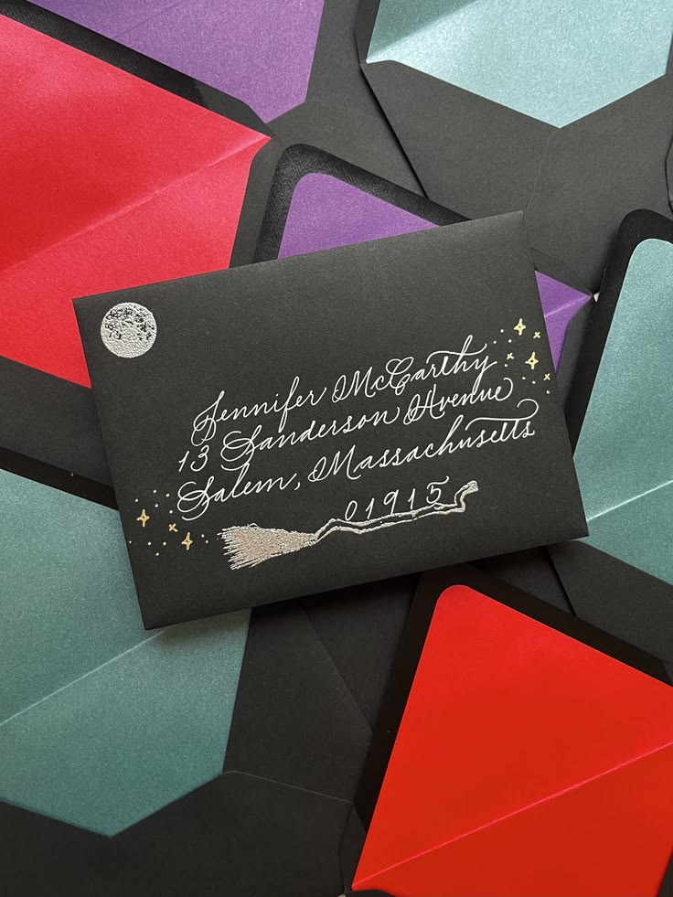 Black envelopes with hand calligraphy and silver embossed de