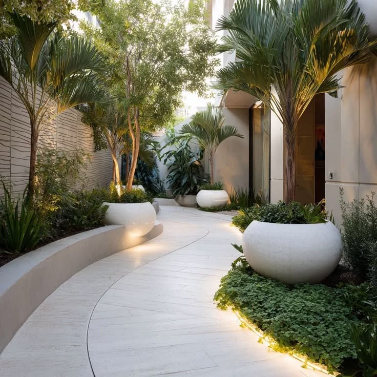 A sleek, curved white stone path lined with large rounded pl