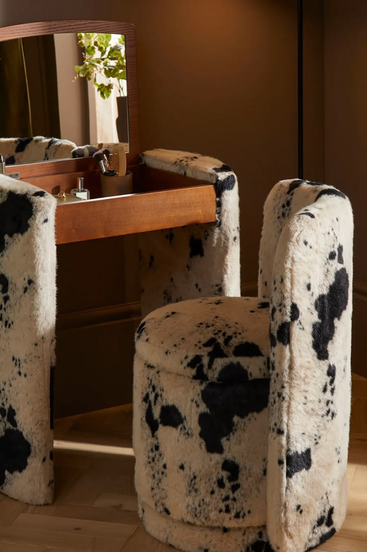 Bold cow print upholstery turns a compact dressing chair int