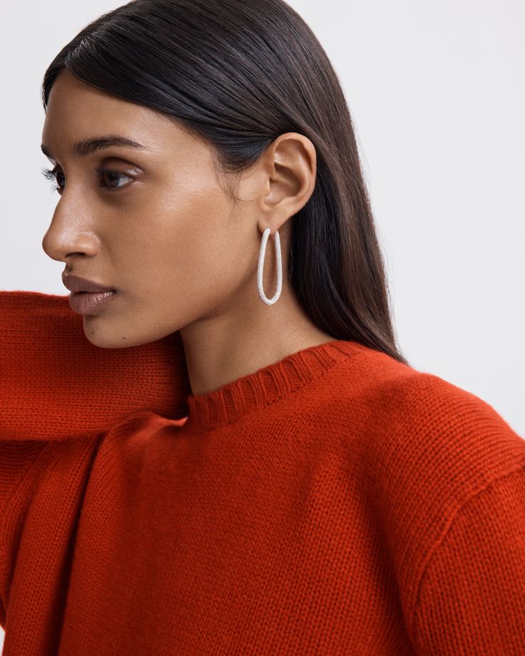 A pair of small drop hoops made from 18k Gold in our signatu