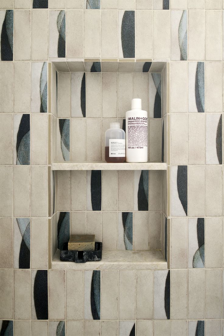 Custom shower niche with exposed tile edges and quartz shelv