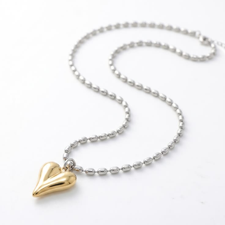Silver bean links neatly align.
Gold twisted heart catches t