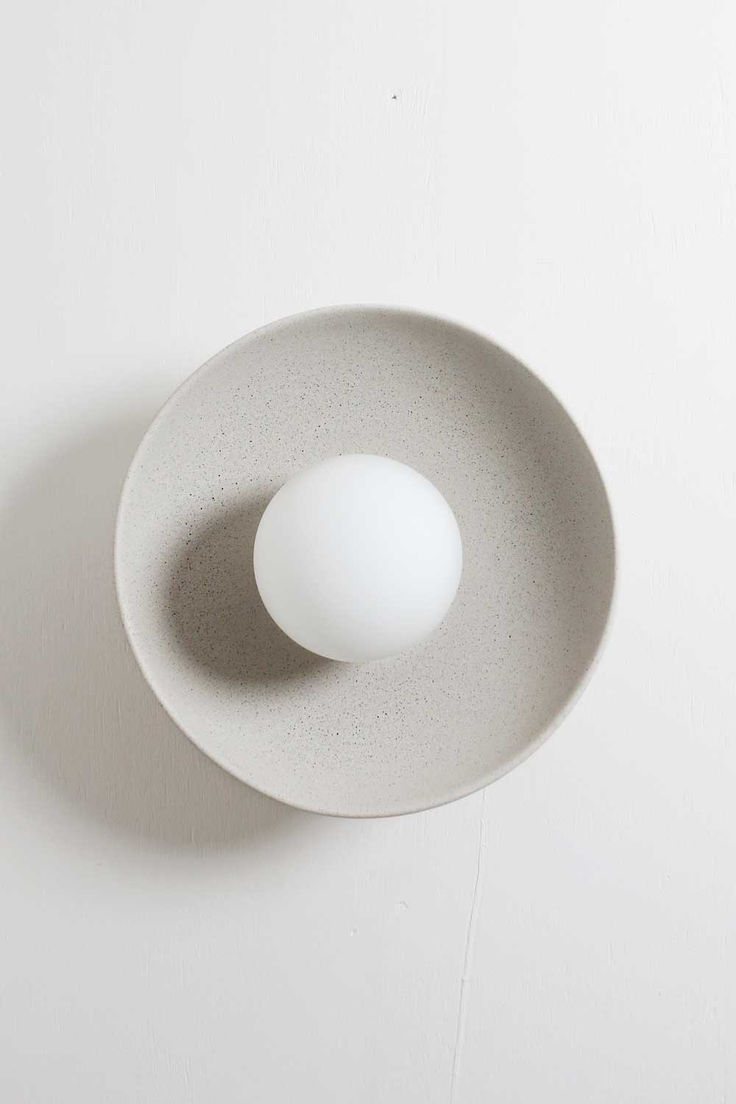 A simple dish frames a ball light to create a sweet wall sco