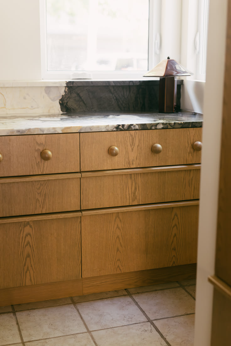 Custom kitchen design with white oak cabinetry, leathered ma