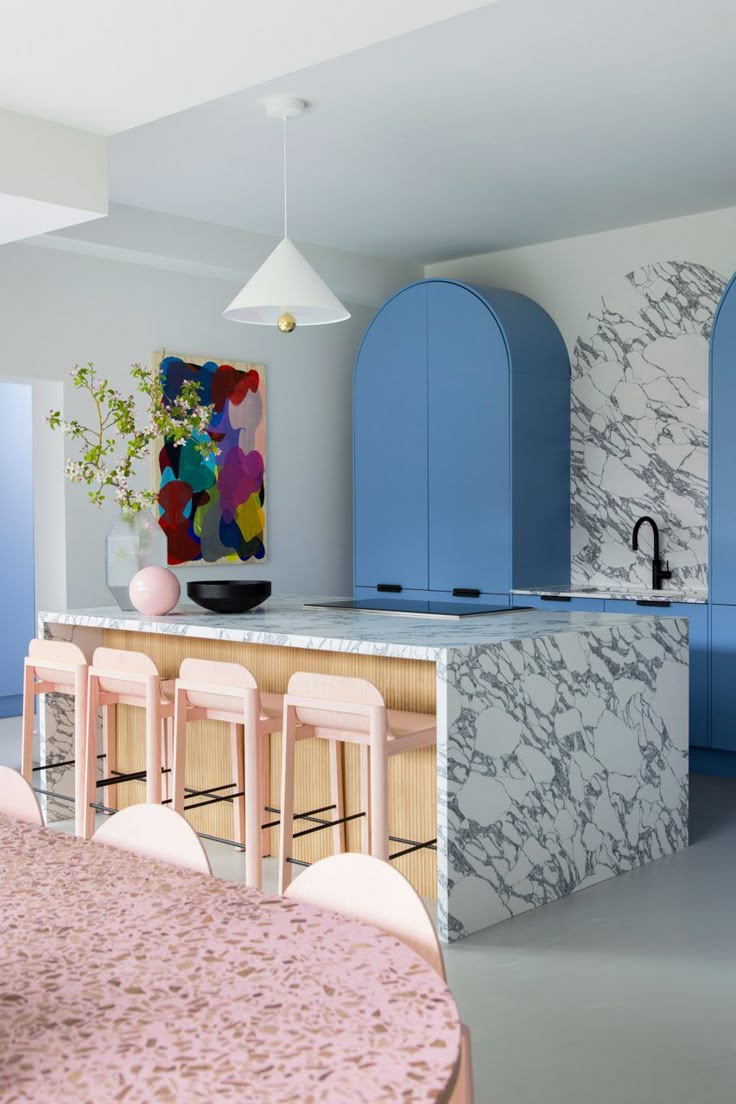 The kitchen is defined by sky-blue cabinetry and marble coun