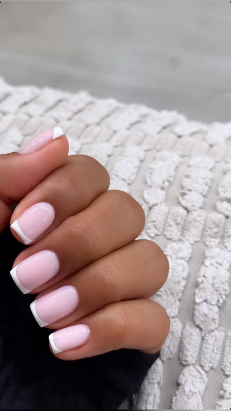 Glossy pink nails with crisp white French tips for a polishe